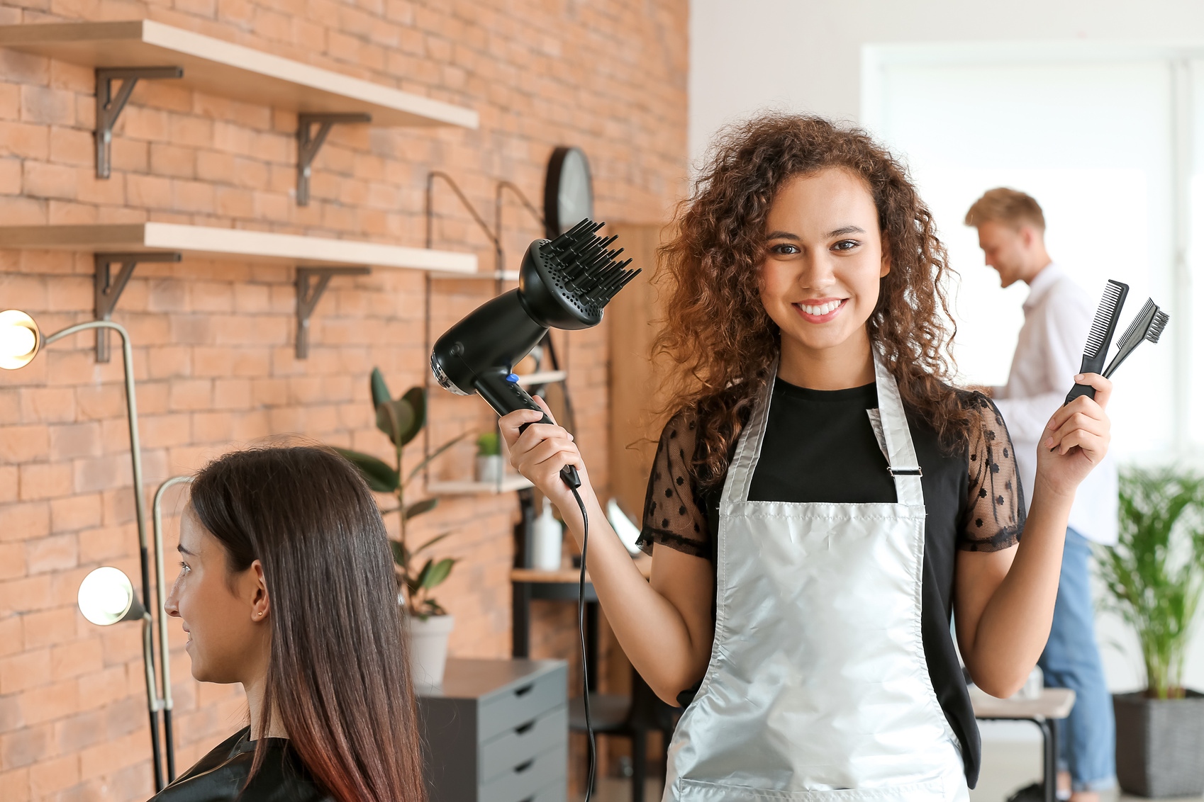 Young African-American Hairdresser in Beauty Salon